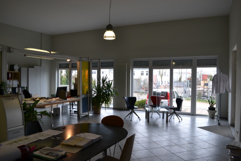 Offenes Bürogeschoss mit raumhoher Glasfront und Pendelleuchten