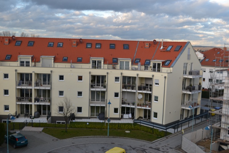 Fertiggestellte Wohnanlage aus seitlicher Perspektive mit angelegten Außenanlagen